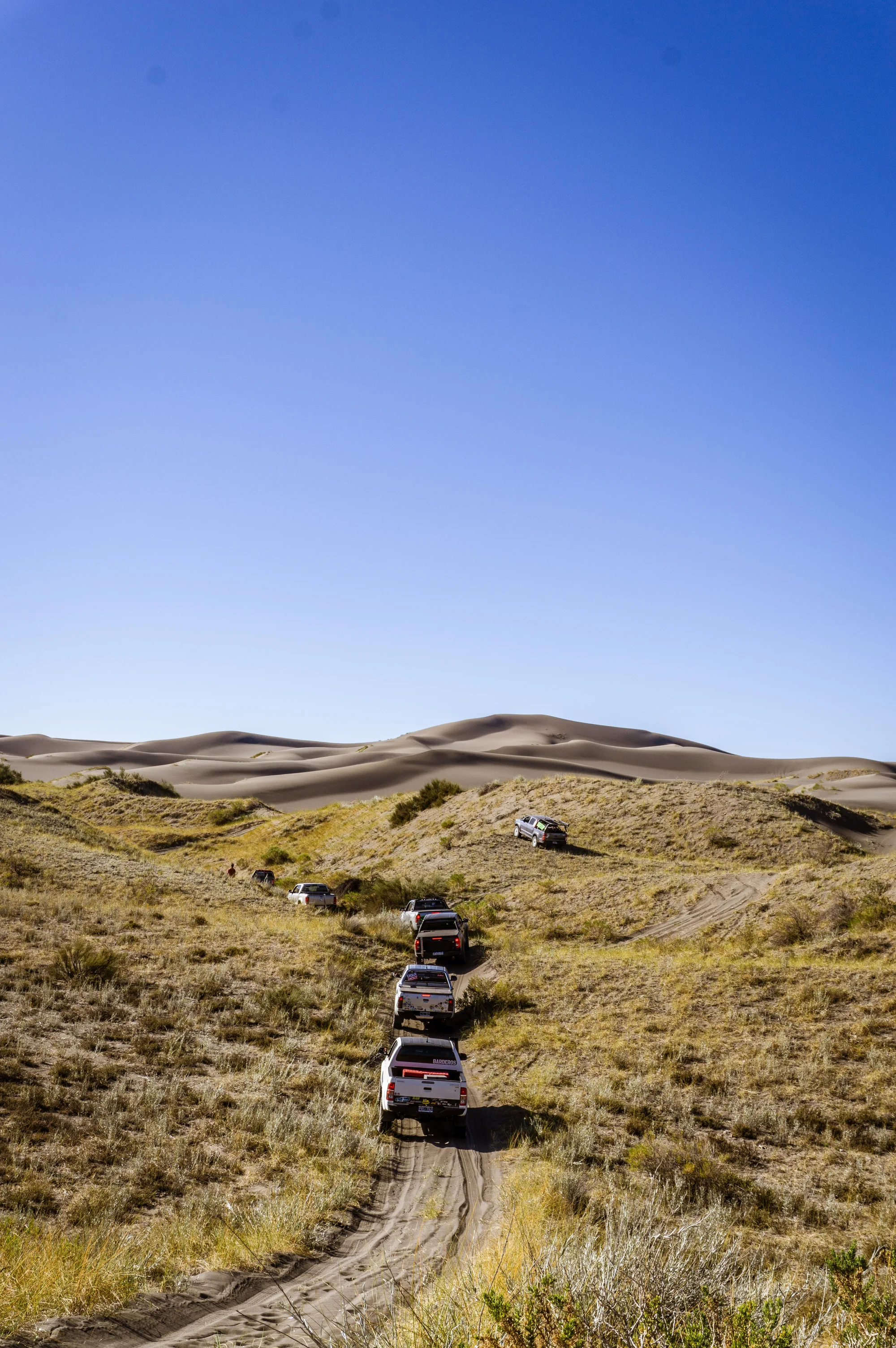 Caravana off road avanzando por un paisaje de dunas